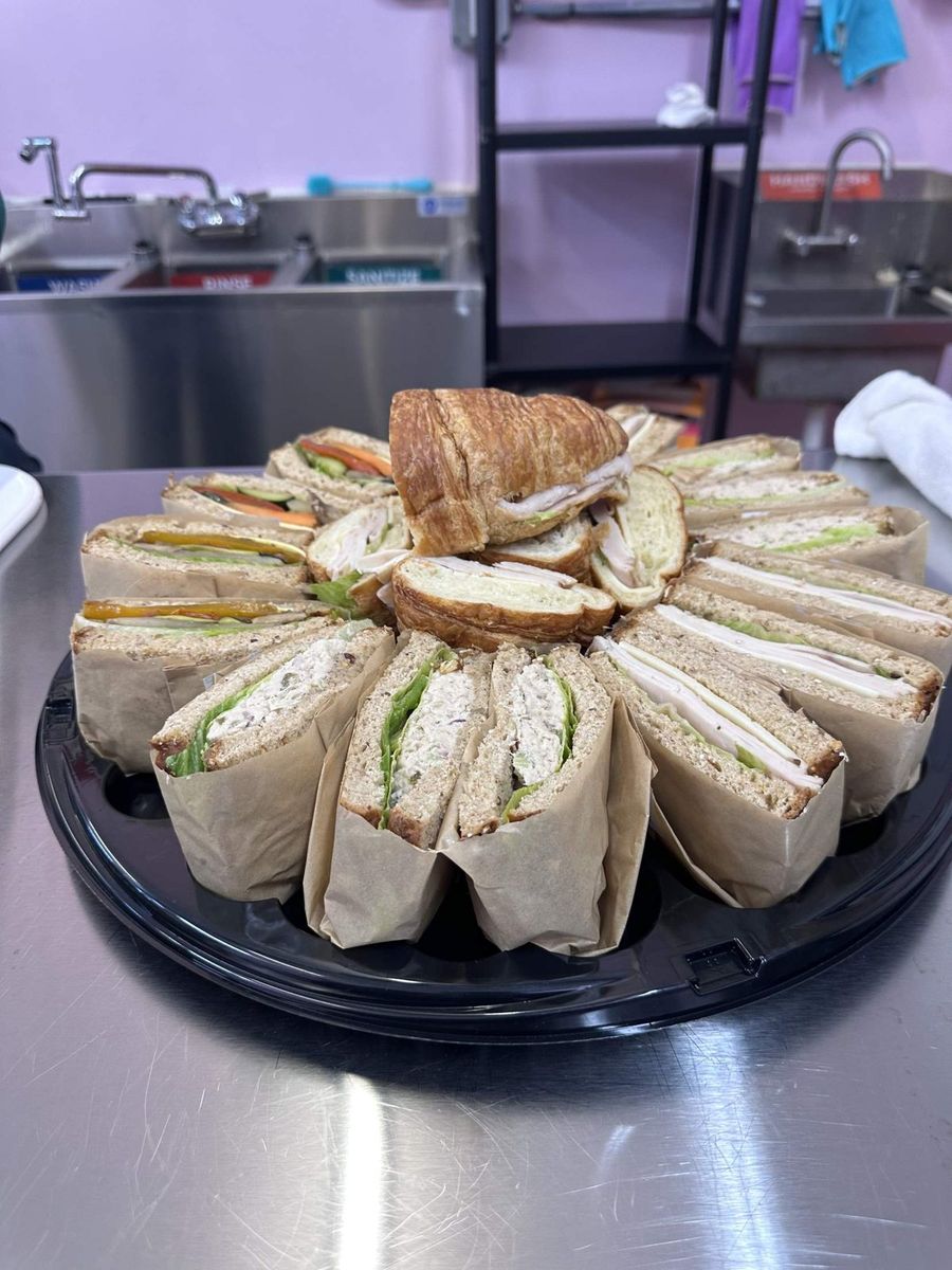 A Peace of Mine sandwich platter of wrapped sandwiches and turkey croissants in the shop kitchen